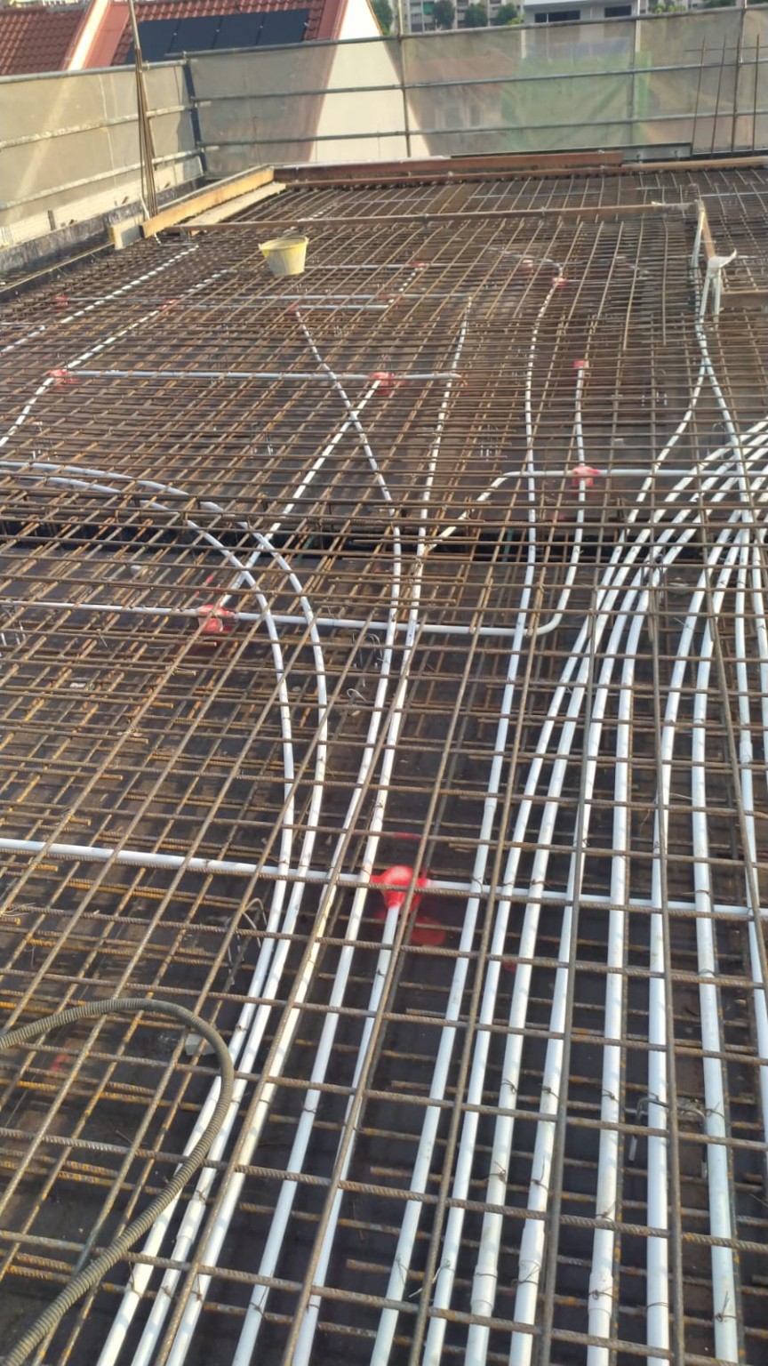 Electrical and mechanical conduits coordinated within slab reinforcement